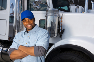 Image of smiling long haul trucker and his truck