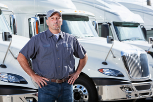Image of long haul trucker in front of trucks