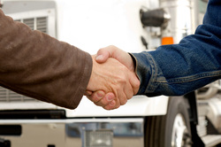 Image of customer and long haul trucker shaking hands
